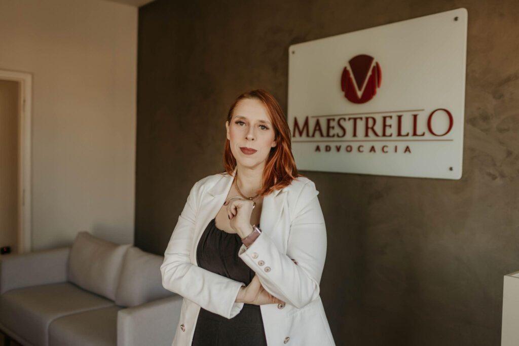 Dra. Laís Maestrello em frente ao logo Maestrello Advocacia