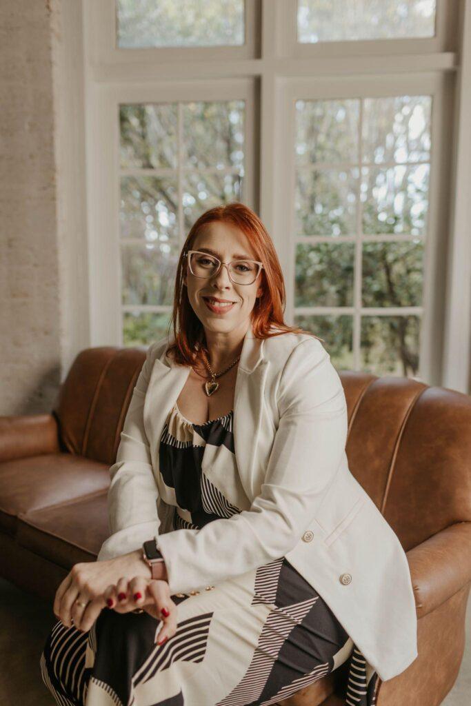 Dra. Laís Maestrello, advogada trabalhista, sentada no sofá do escritório
